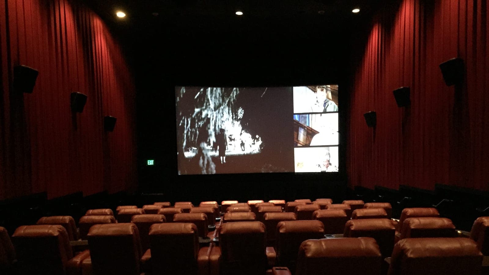 Empty rows of brown leather recliner seats facing a lit screen in an AMC auditorium in Herndon, Virginia