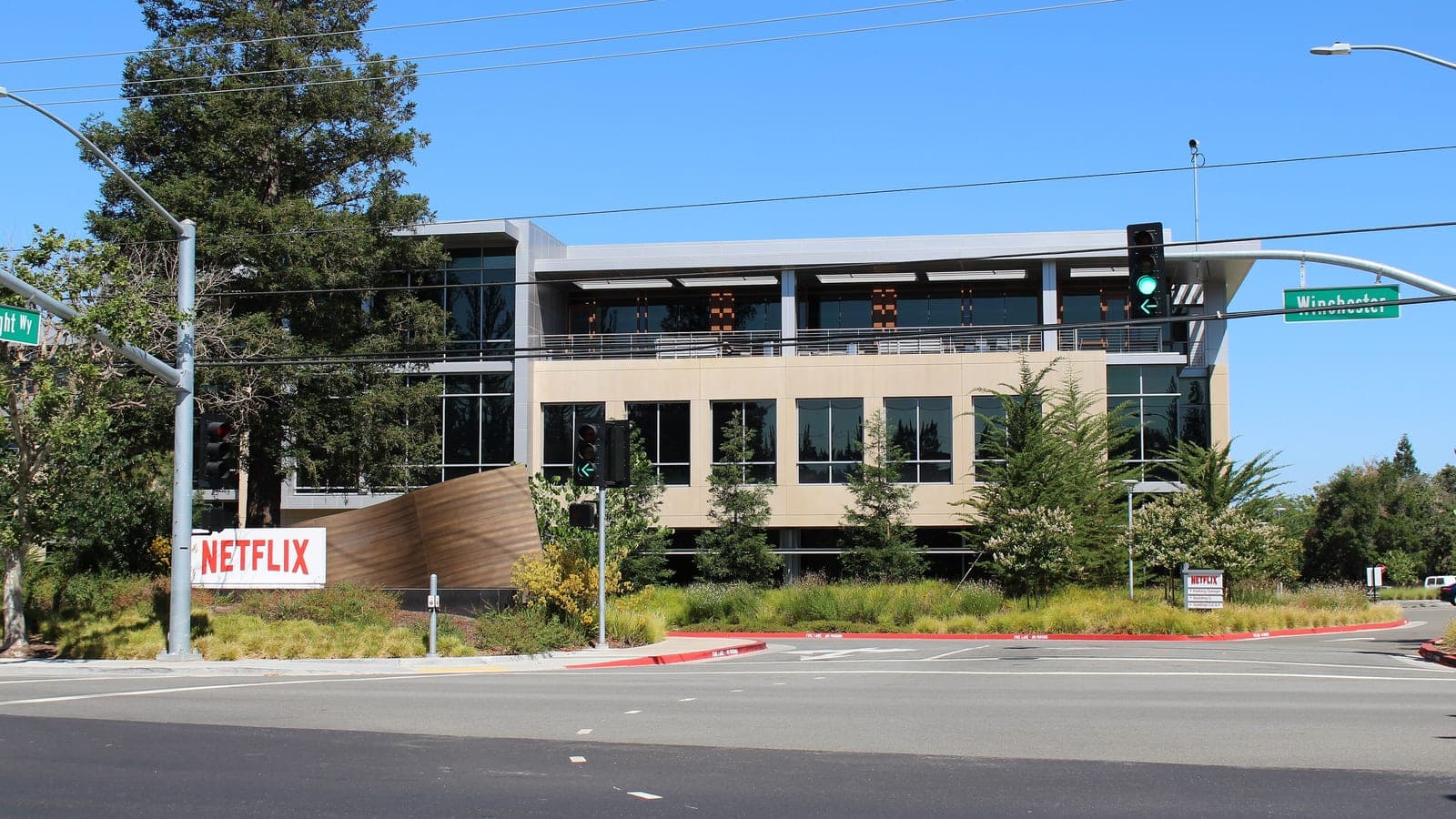 Netflix office building at 101 Albright Way on its Los Gatos, California headquarters campus, with a red Netflix sign at the street corner