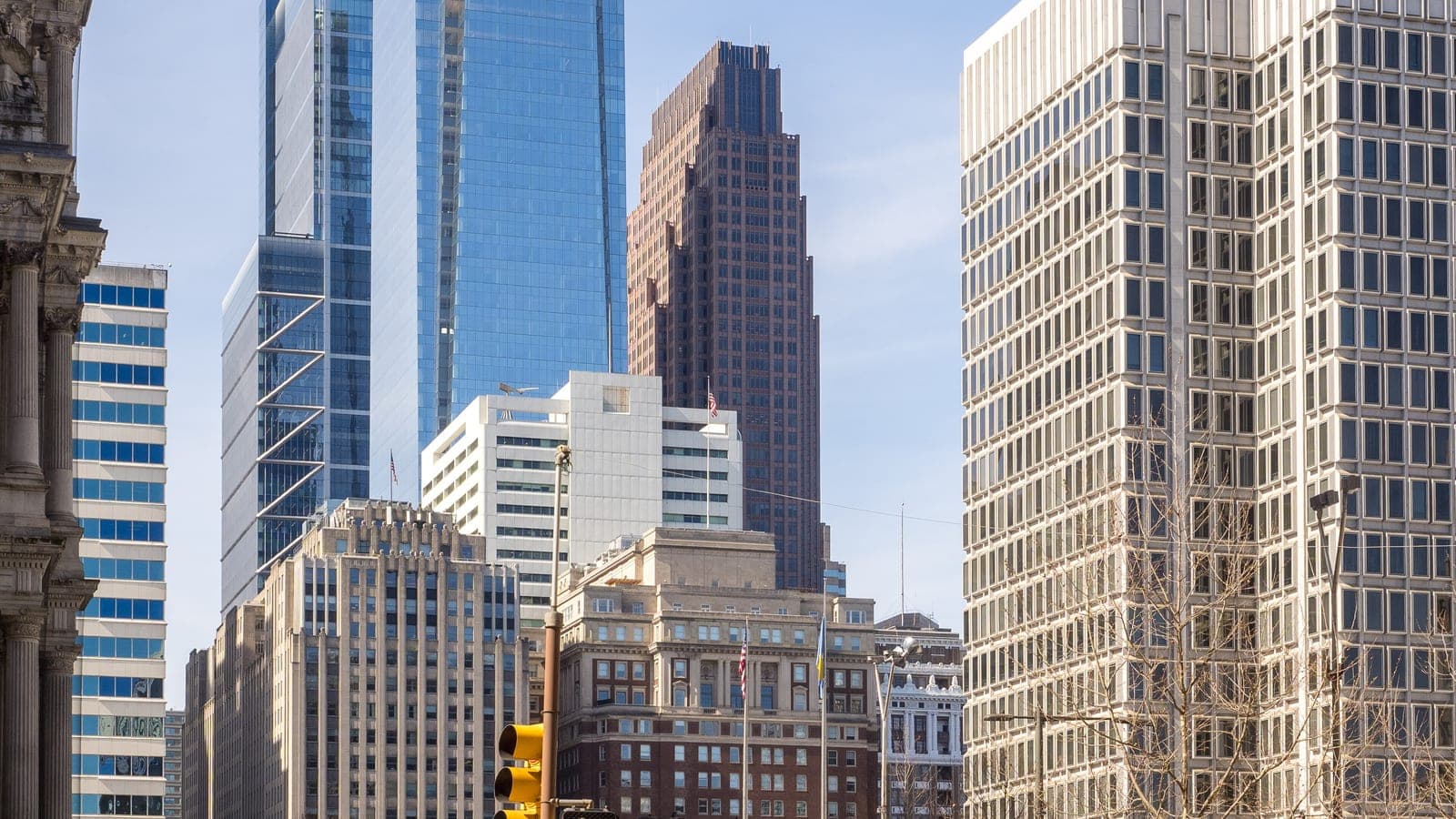 The glass Comcast Center skyscraper rising over Center City, Philadelphia, seen from a pedestrian crossing near City Hall.